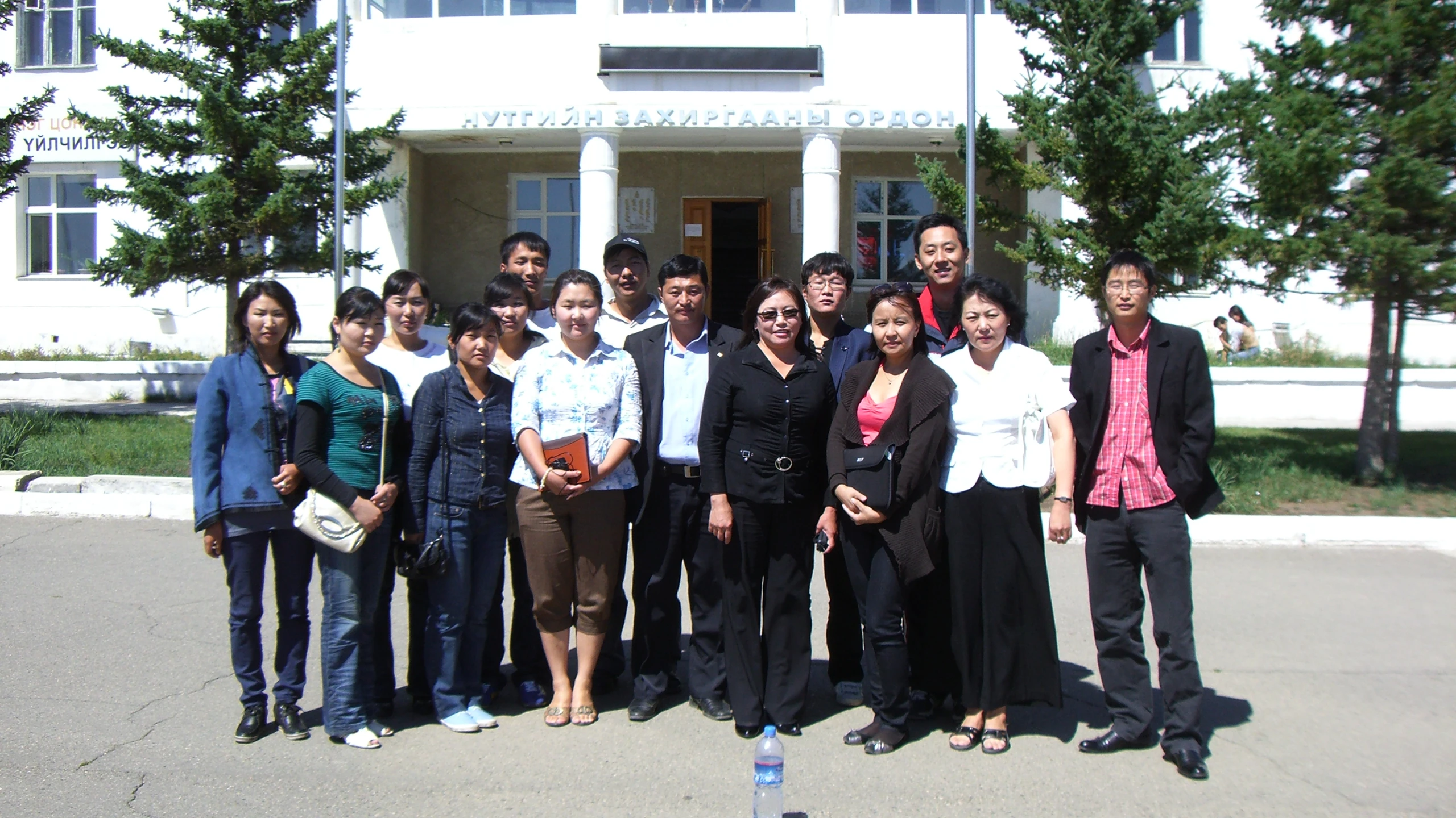 many people standing on a street corner in front of a building