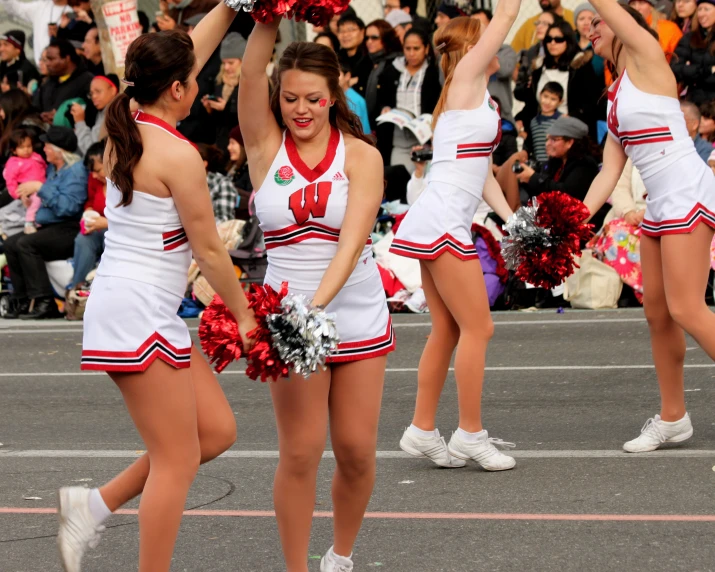 a couple of women playing a game of cheer on top of the street