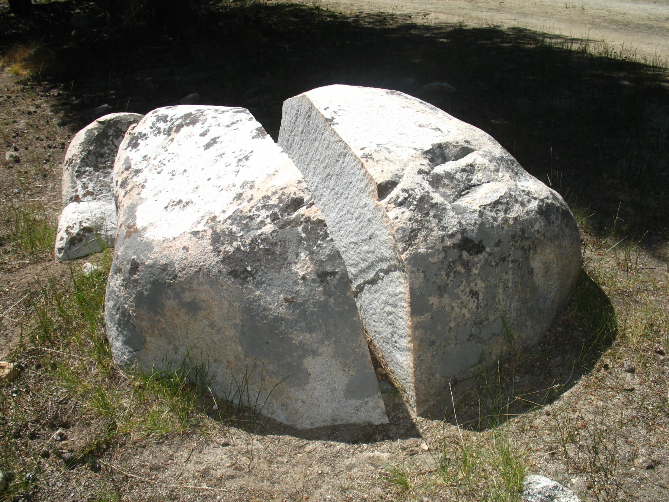 two large rocks in the middle of a grass field