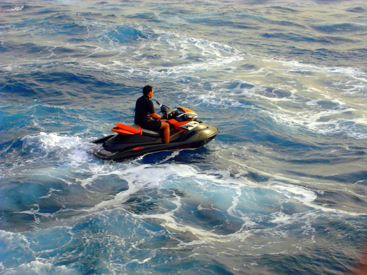 a man on a jet ski with an orange helmet in the water