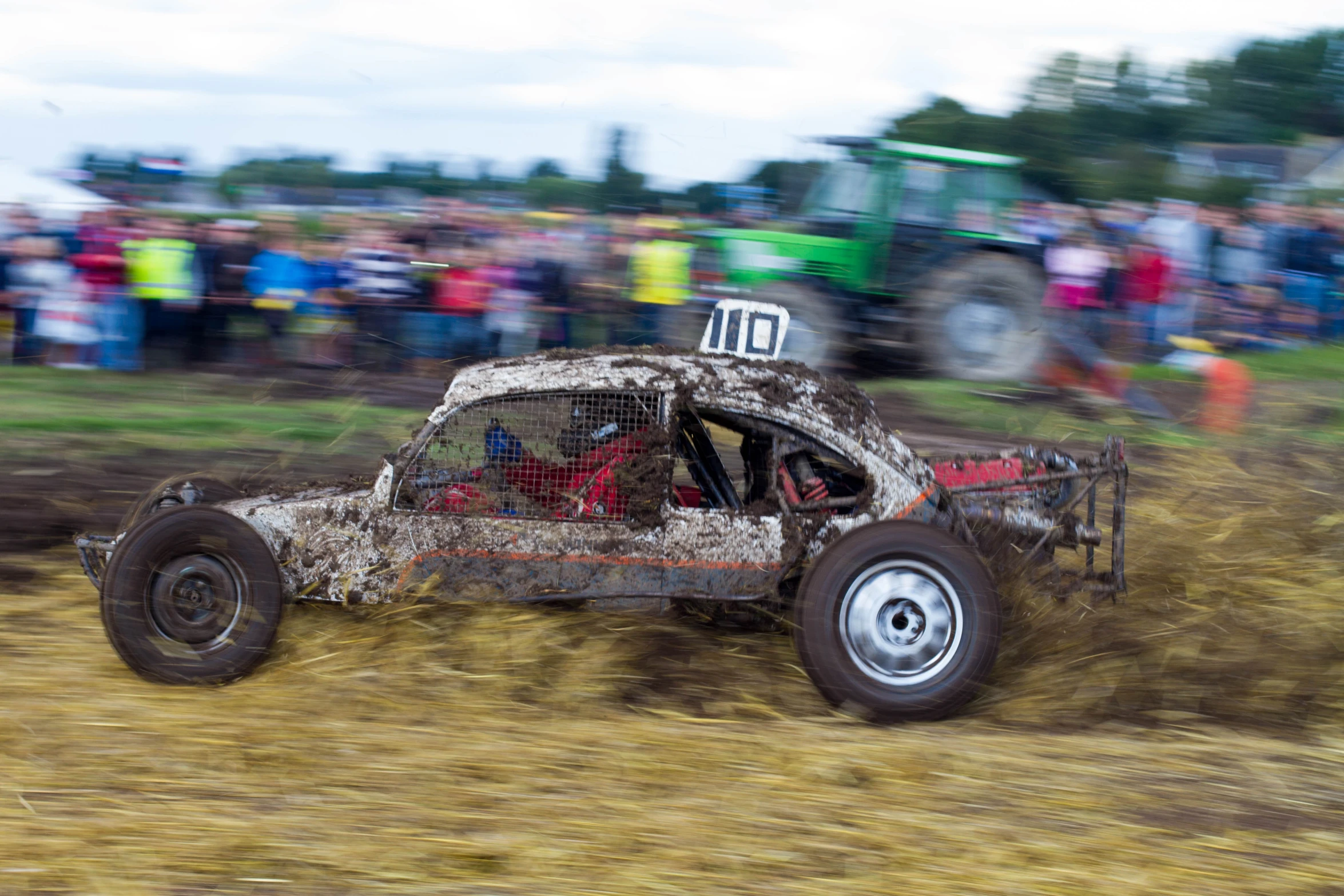 a dirt buggy with lots of mud driving in the air