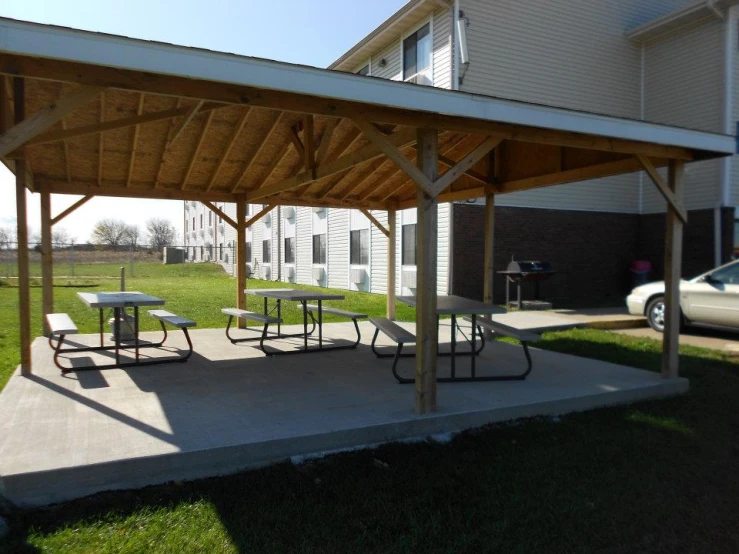 the covered picnic table sits next to a car on the road