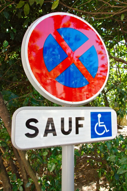 two signs posted together in front of green trees