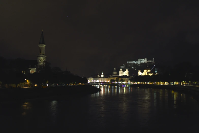 a body of water near buildings at night