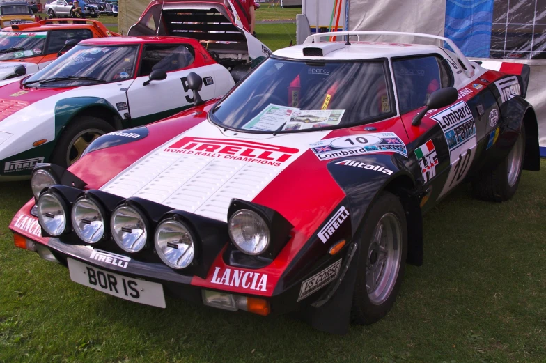 some classic cars are parked together on some grass