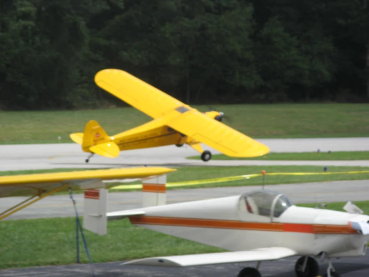 there is a yellow plane and a red one on the tarmac