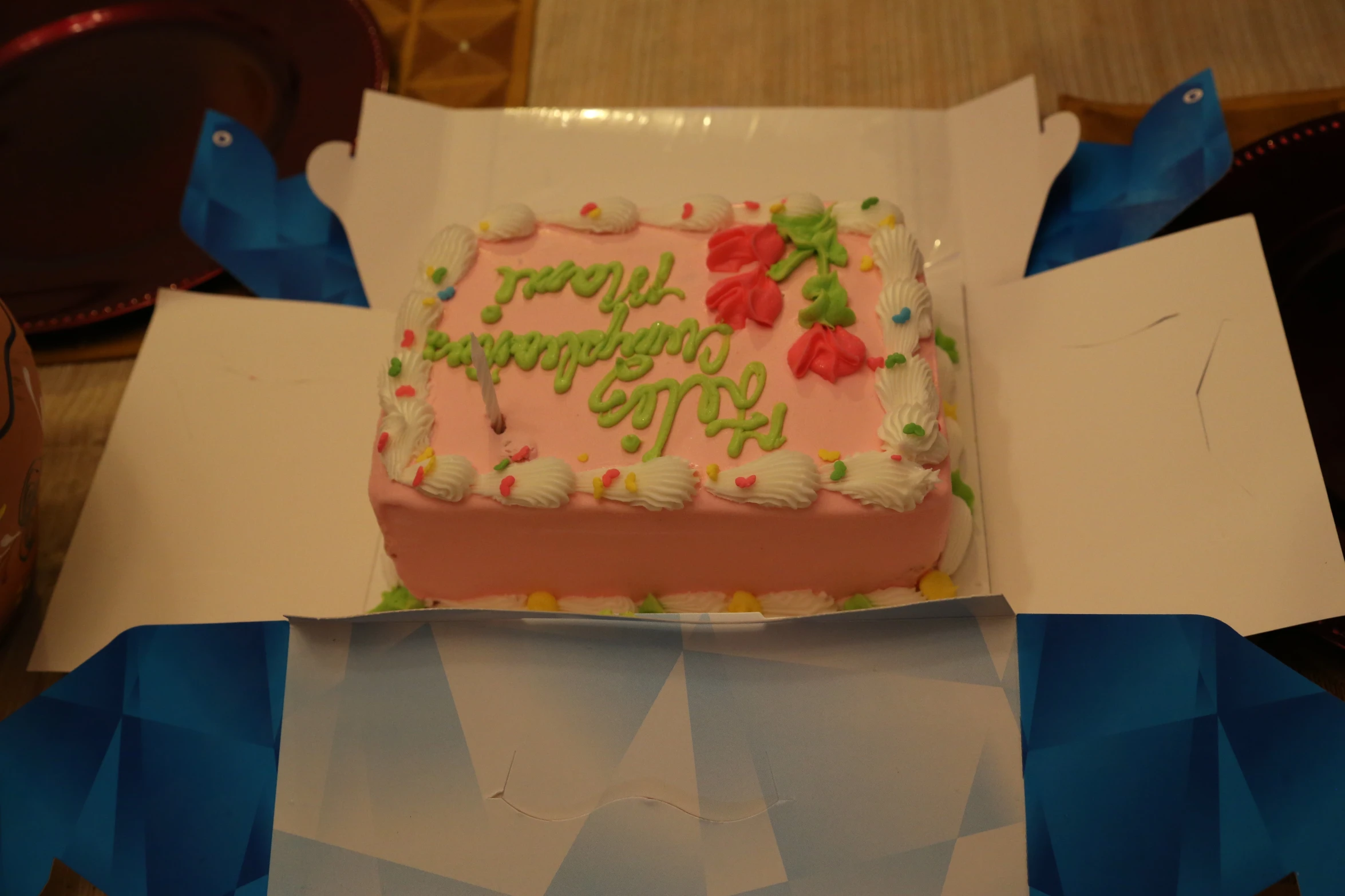 a decorated birthday cake in a box on a table