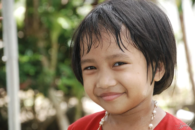 a child is posing for a po while smiling