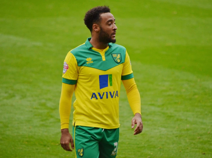 man in a yellow and green soccer uniform looking off into the distance