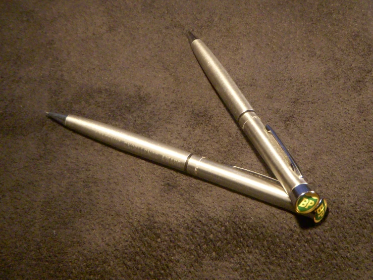 two pens are on the carpet, one is very close to the other