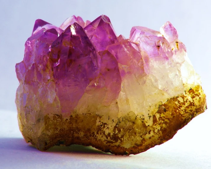 several pink crystals sitting on top of a white surface