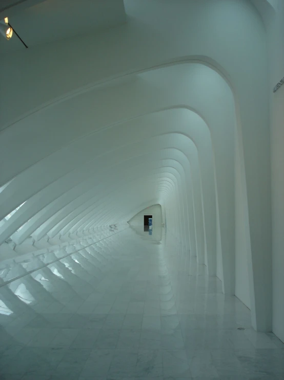 a very long tunnel with white tiles on the floor