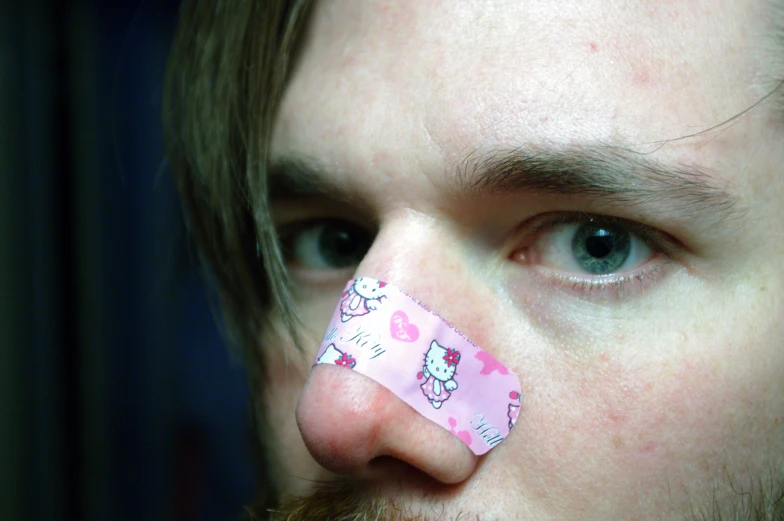 man with a nose tape over the eyes of someone