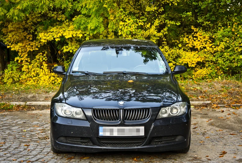 the front end of a bmw car parked in a gravel driveway
