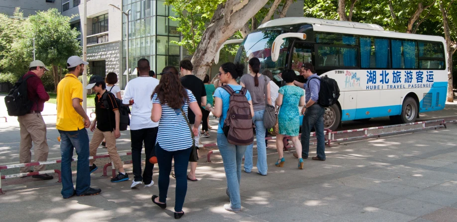 many people boarding a bus on a city street