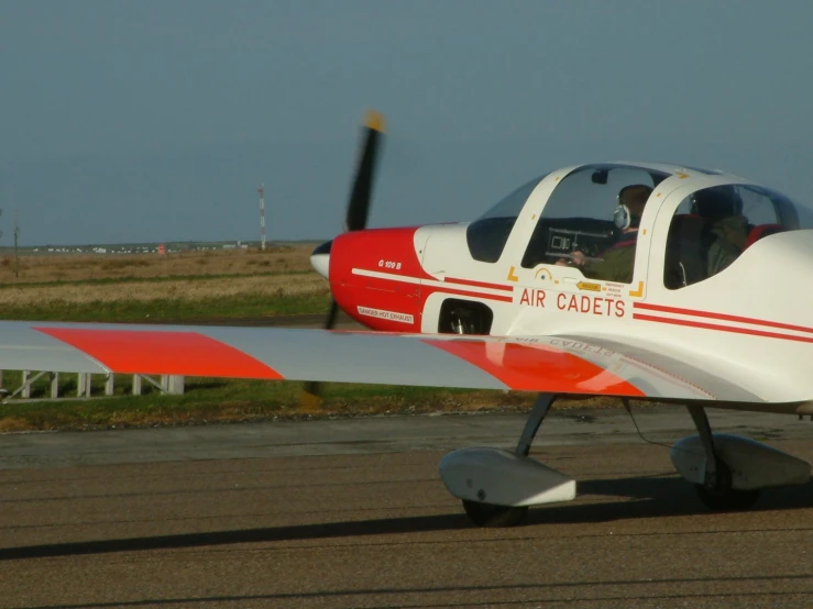 small prop plane on tarmac with a pilot inside
