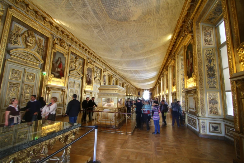 a large hall with golden decorations and people