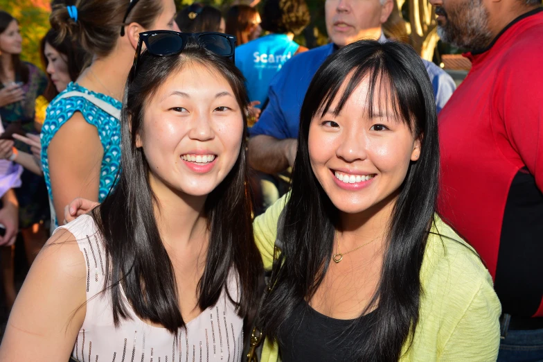 two girls standing next to each other in front of a crowd