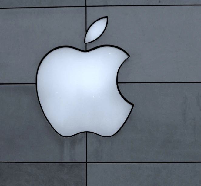 a white apple logo on top of a gray wall