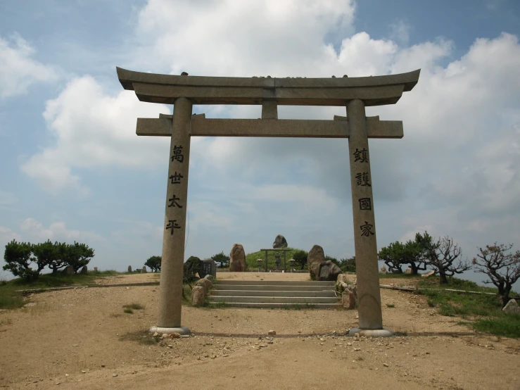 a large stone arch sits on the sand