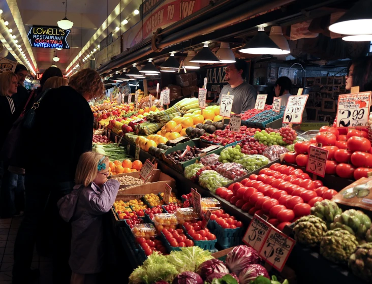 people at the vegetable and fruit market waiting to purchase food