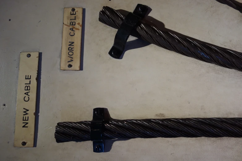 two black ropes with tags attached to them