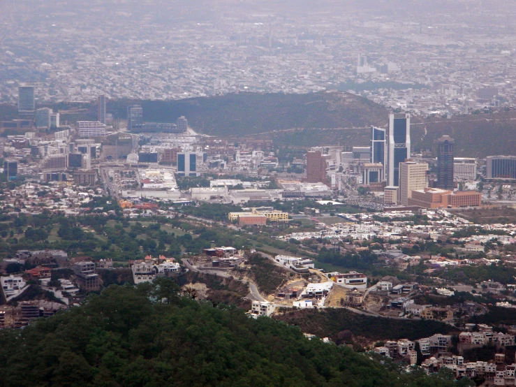 a city with a huge tower of a el and mountains in the background