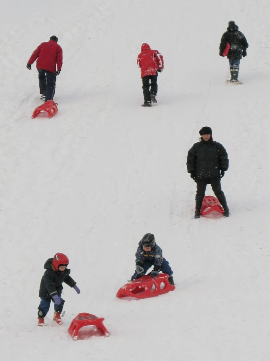 four people playing in the snow while wearing winter gear