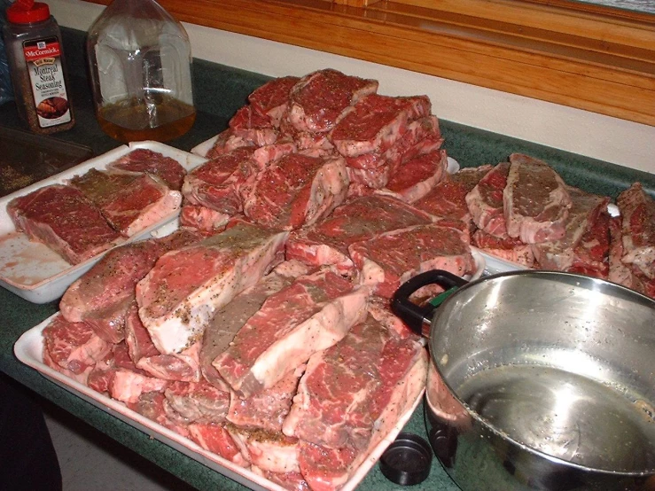 a counter with several trays of raw meat on it