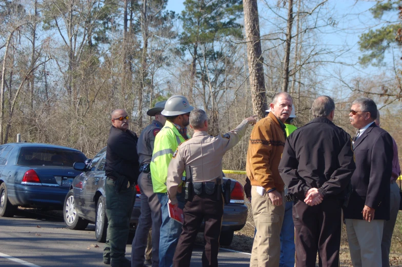 people stand in front of the police line watching as traffic goes by