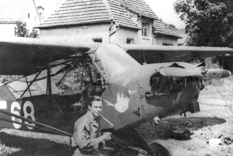 a man standing next to an old airplane