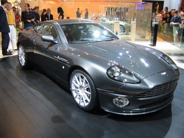 there is a shiny silver colored car parked in the showroom