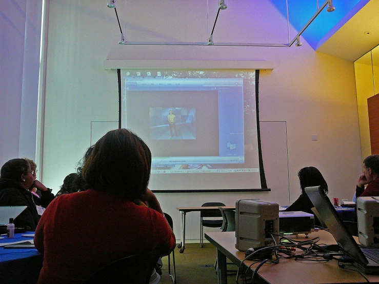 several people are in a conference room with white walls