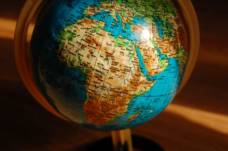 a blue and orange globe with the borders of the world on it