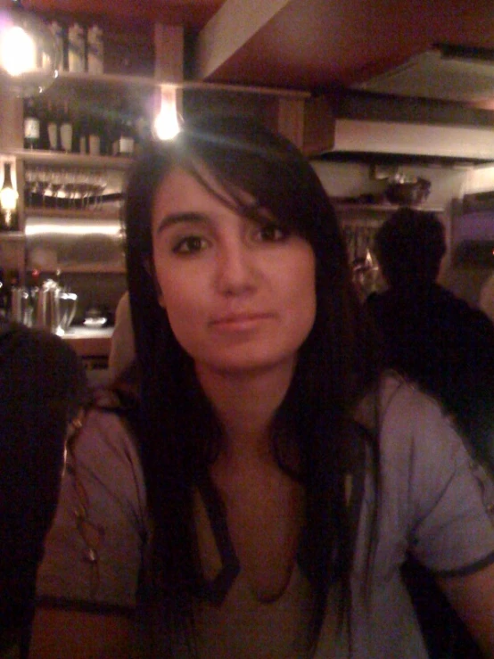 a young woman is sitting in a restaurant and looking at the camera