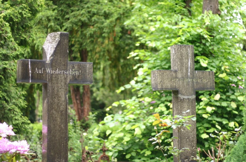 the four crosses are in a garden with flowers and trees