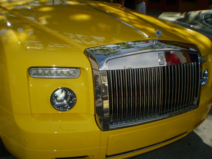 the front grill on a yellow truck that is parked