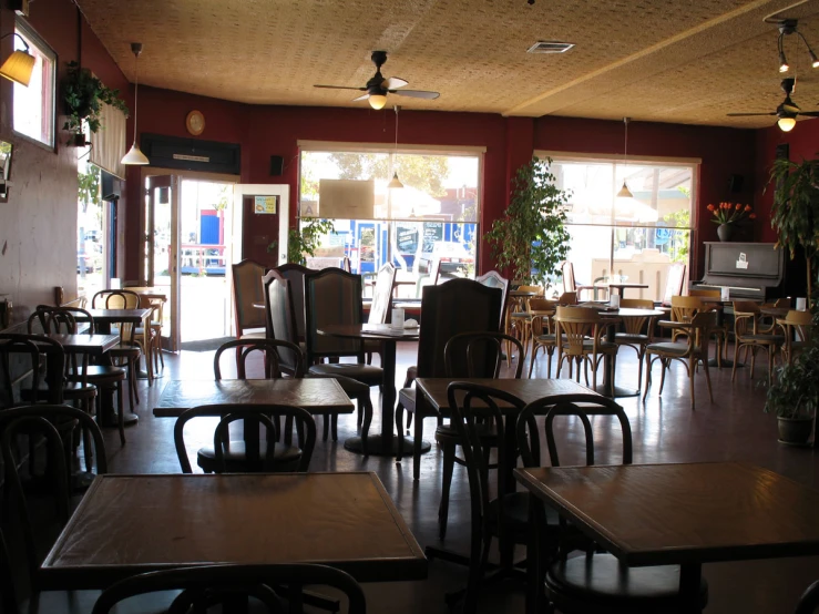a restaurant with many tables and chairs with their doors open