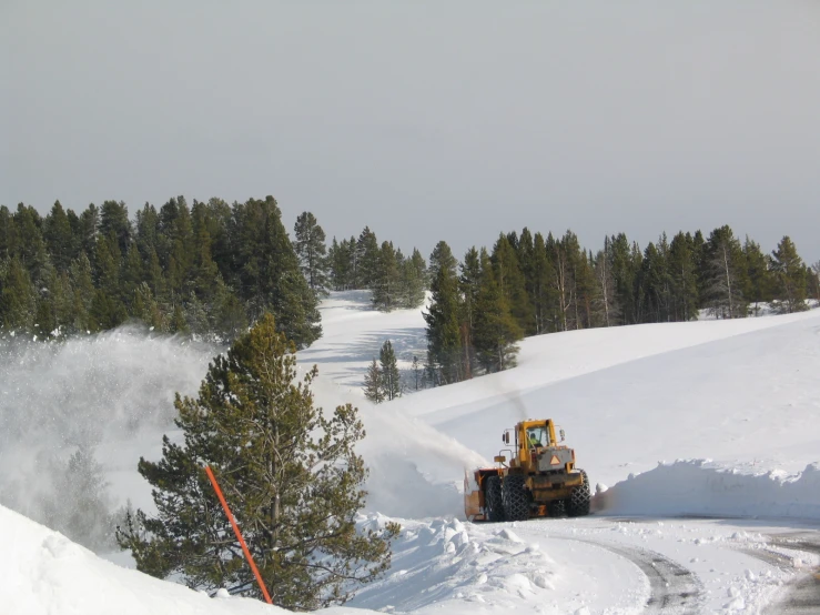 a bulldozer in the middle of a snow filled road