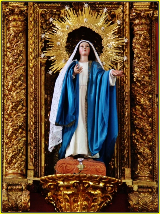 the virgin mary in gold is flanked by a statue