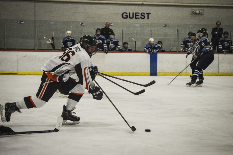 a couple of young men playing a game of ice hockey