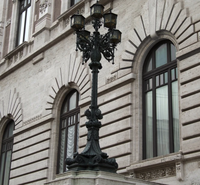 an ornate lamp pole in front of a building