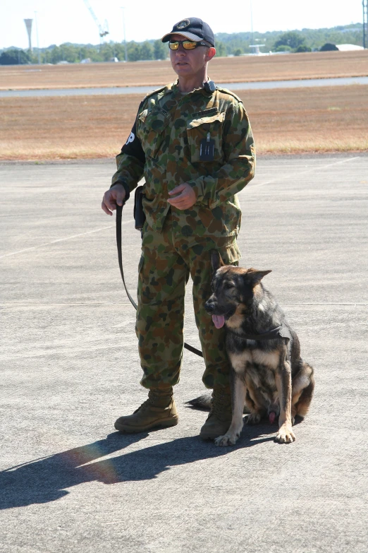 a man in uniform is standing with a dog