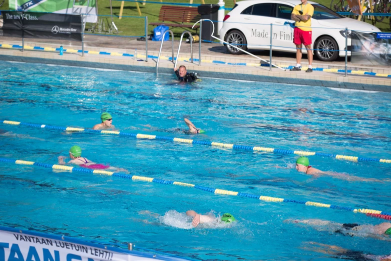 people in a pool, with swimmers and swimmers watching