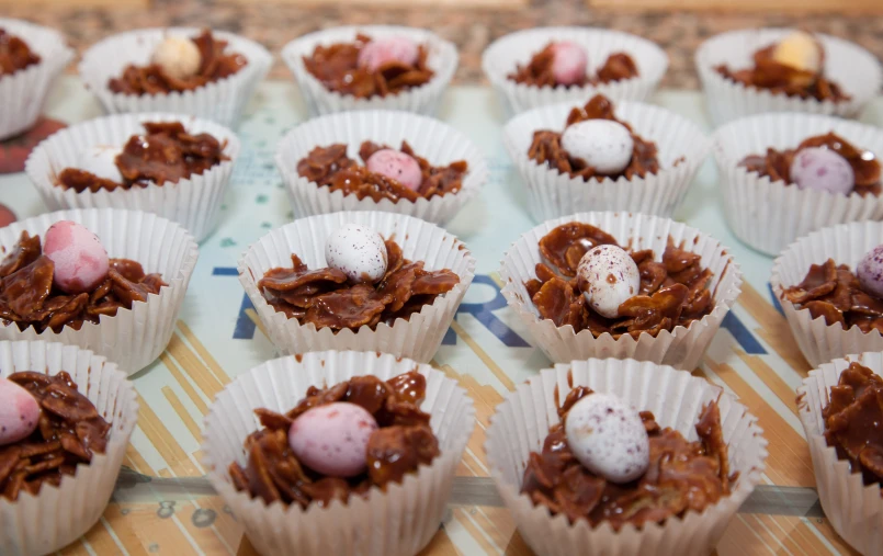 a table full of chocolate cupcakes with small candy candies