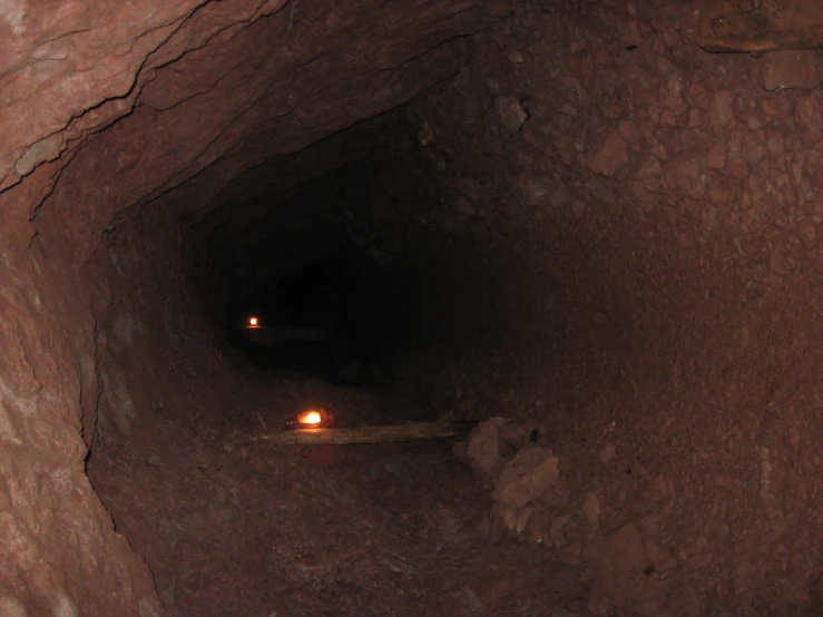 a small tunnel of stones with a light at the end