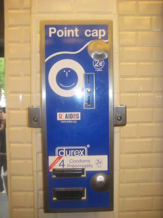 a blue and white vending machine next to a brick wall