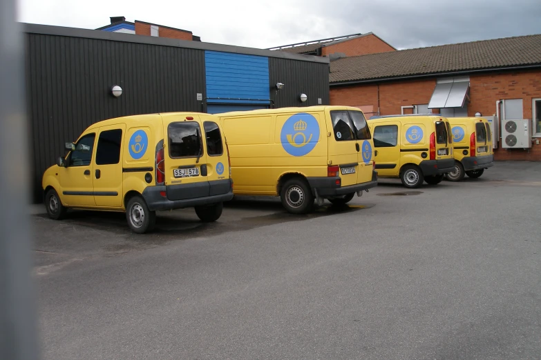 three yellow van parked next to each other