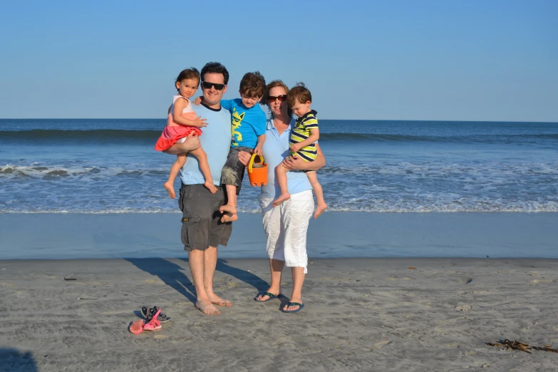 a family of three playing with their young child on the beach