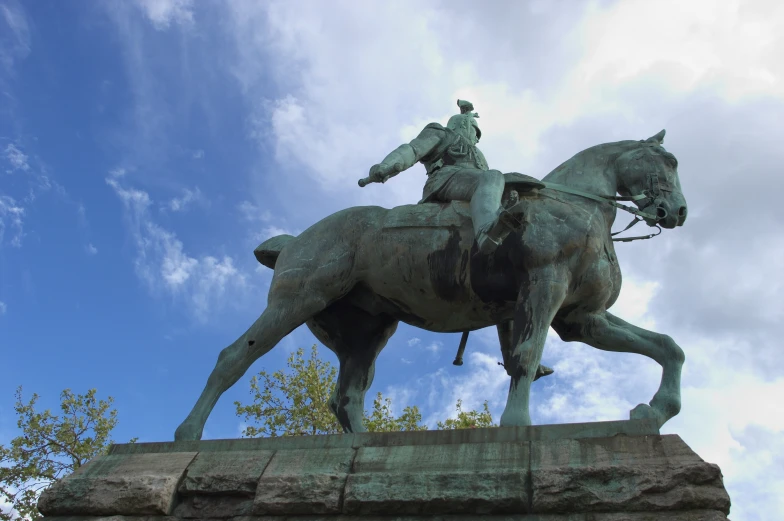 the statue of an old man on a horse, in front of some clouds